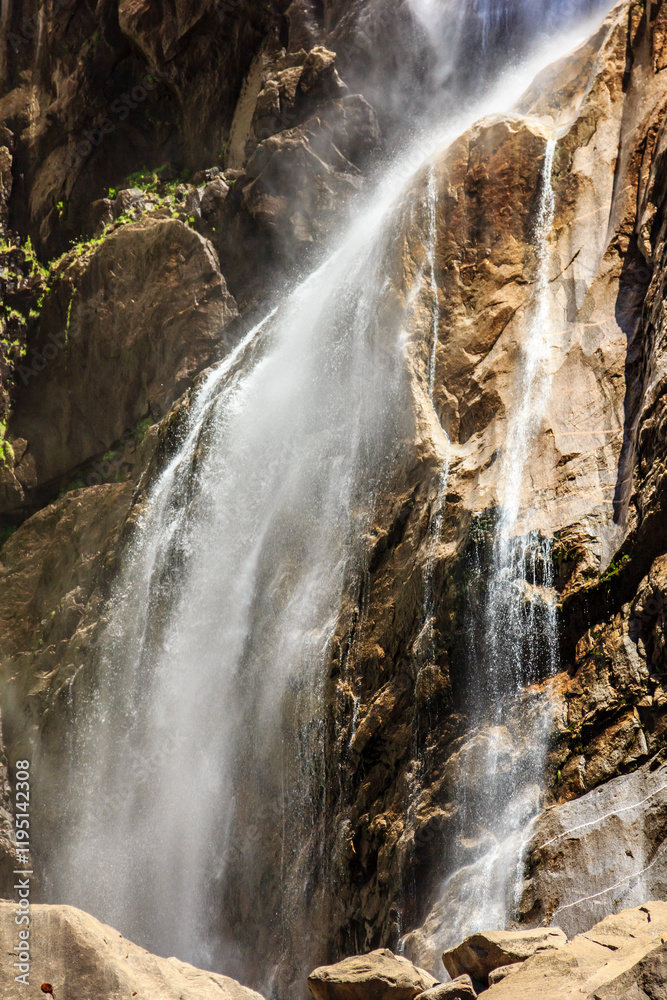 A waterfall is pouring water down a rocky cliff A waterfall is pouring water down a rocky cliff