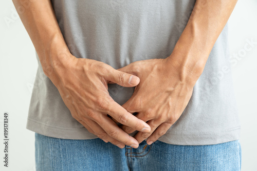 Man hold hand in front of private parts feeling discomfort from disease and inflammation. Venereal, testicular cancer. bladder problems, erectile dysfunction, premature ejaculation, prostate cancer