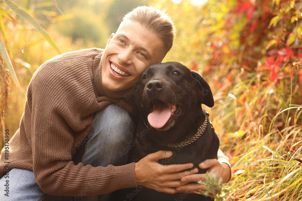 Smiling man hugging cute dog outdoors on autumn day Smiling man hugging cute dog outdoors on autumn day