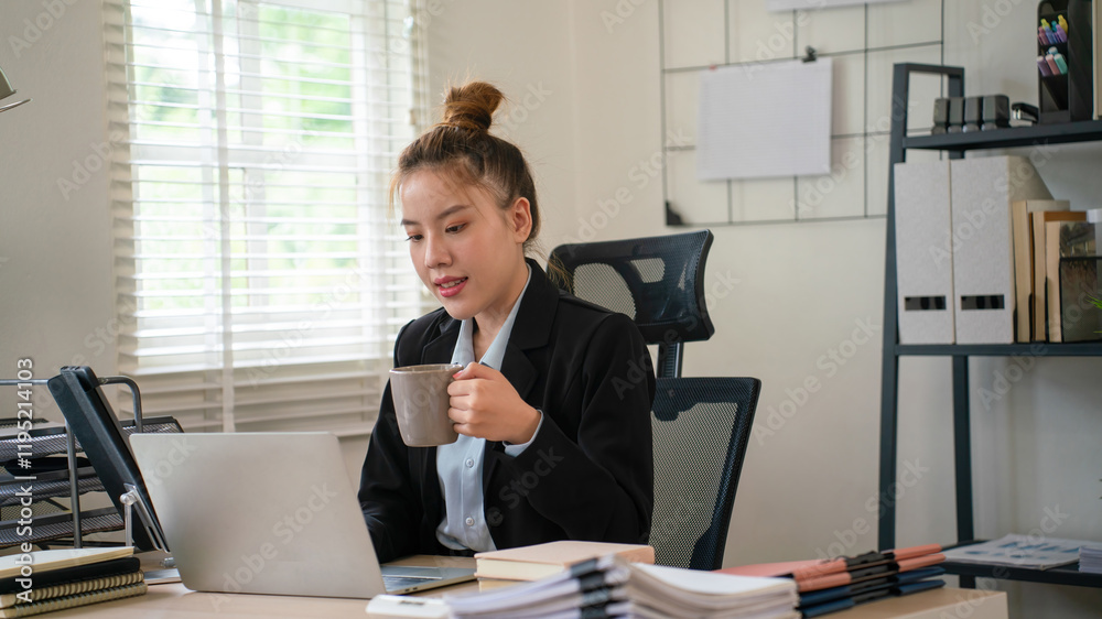 Fototapeta premium Businesswoman sitting at desk on couch in workplace or at home working on laptop and analyzing data on charts and graphs and writing on papers to make business plan and strategies for company.