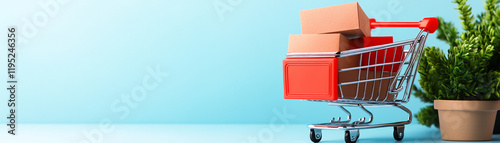 Shopping cart with packages and a potted plant against a light blue background. photo