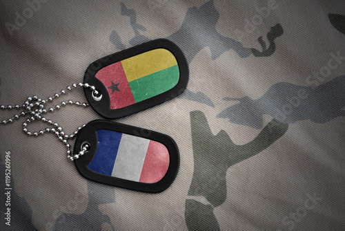 vintage army blank, dog tag with flag of guinea bissau and france on the khaki texture background. military concept.