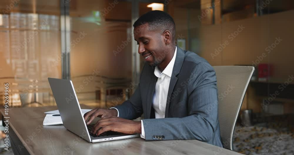 Smiling African businessman, entrepreneur dressed in formal attire opens laptop and start working, answers on business mails, review information, tracking progress looks satisfied. Workflow, lifestyle