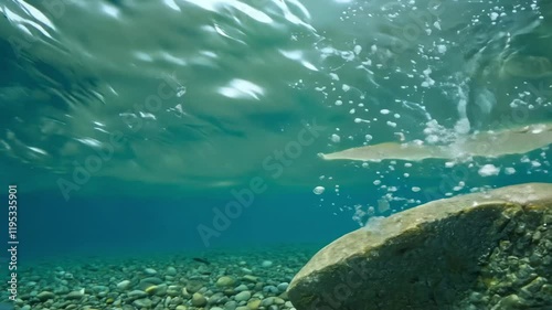 Underwater scene showing bubbles and splashes around a submerged rock.