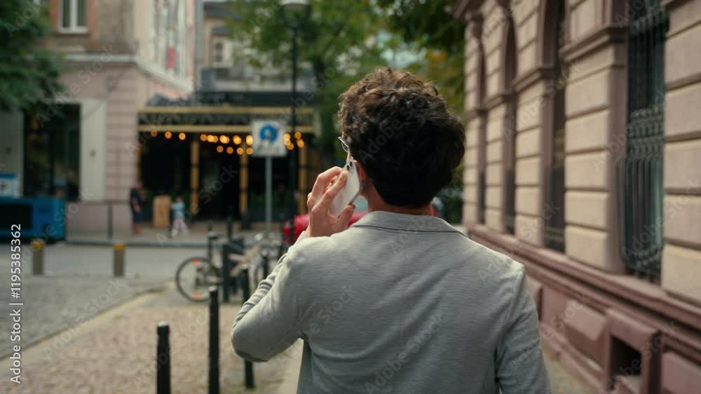 Back view from behind unrecognizable man unknown guy male talking mobile phone call in city communicate cellphone calling walking go outdoor walk conversation speaking smartphone outdoors street going