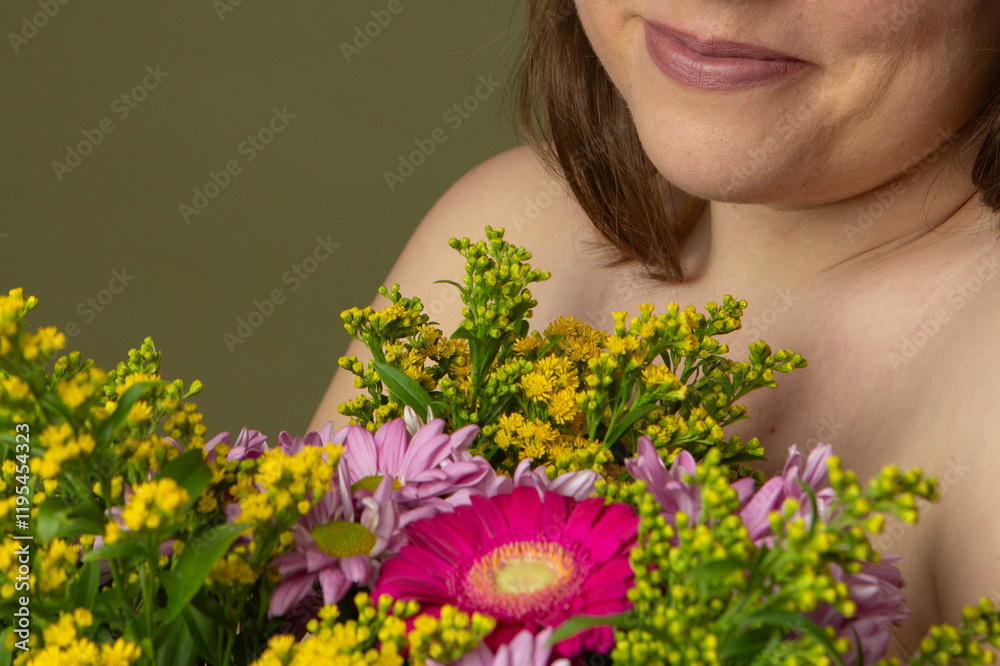 Curvy woman with clear skin imperfections in studio, holding a bouquet of multicolor flowers, unrecognizable Curvy woman with clear skin imperfections in studio, holding a bouquet of multicolor flowers, unrecognizable