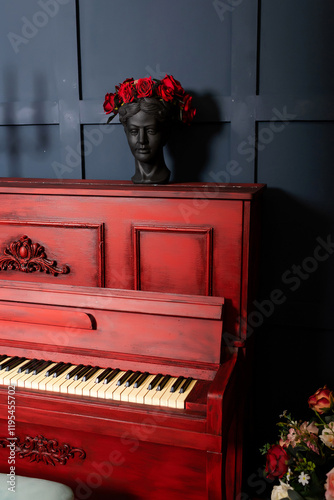 red piano against dark blue wall with candles. photo zone with piano in photo studio
