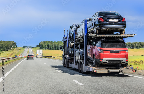 Fototapeta Naklejka Na Ścianę i Meble -  car transporter truck transports cars along a country road