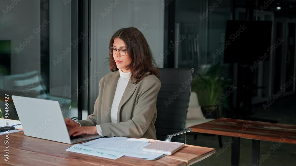 Young professional it specialist latin hispanic business lady working on laptop pc sitting at desk in modern office space. 30s middle eastern indian woman using computer technology app for work online