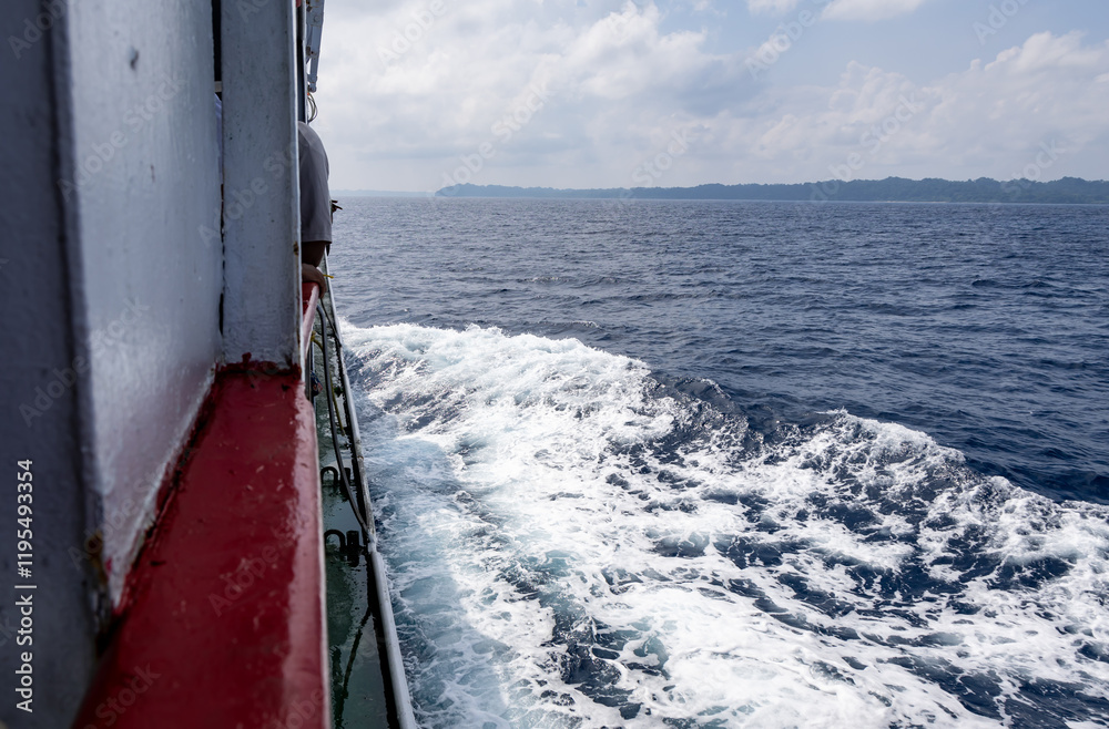 Obraz premium serene sea horizon with ship water trails cutting through sea water under bright blue sky