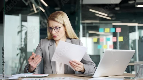 Confused distracted businesswoman having difficulty with paper work in office. Puzzled female employee is busy with accounting, having problems with task of financial report while reviewing documents