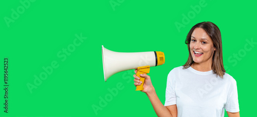 Woman enthusiastically holding a megaphone against a vibrant green background photo