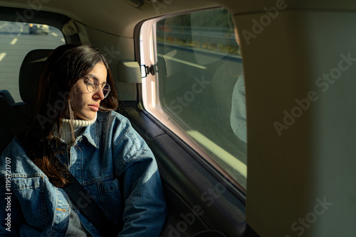 A female passenger taking a nap in the car, resting comfortably with her eyes closed