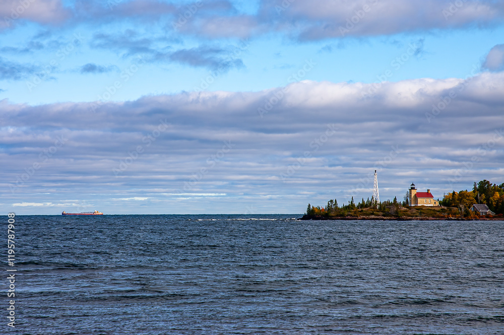 Obraz premium Lake freighter passing a lighthouse