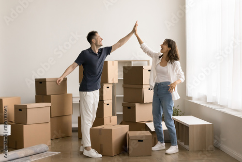 Photography Young couple stands in spacious unfurnished living room of their new home, surro