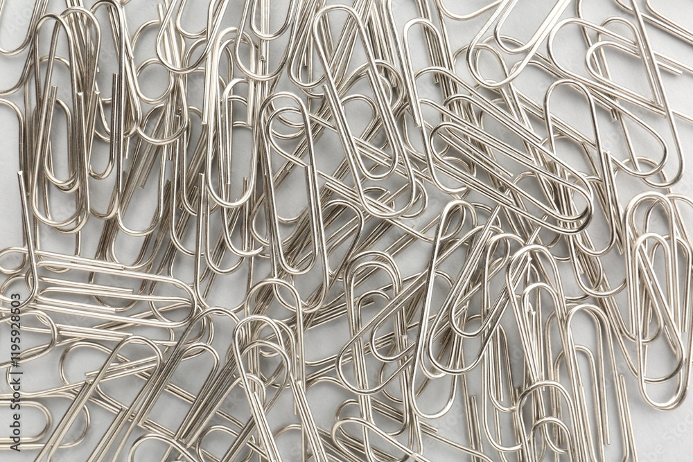 Metal paper clips on light background, top view Metal paper clips on light background, top view