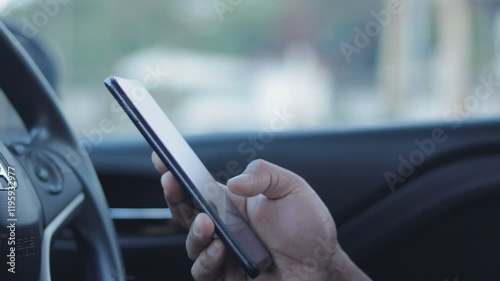 B roll - Closeup of man hand using smartphone while seated comfortably inside a car. A person using a mobile phone to check email for work or text SMS messages. Online business communication concept.