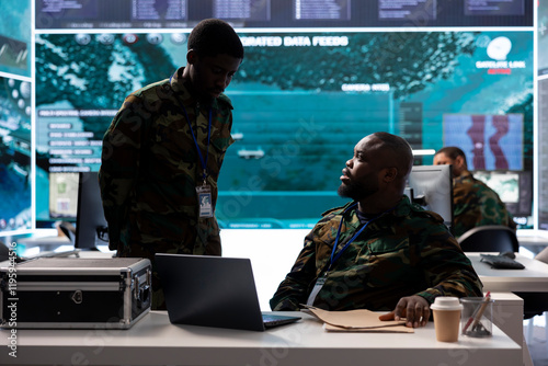 Experts collecting real time cctv data and transmitting crucial information to help troops in the field. Soldiers collecting important details from classified files in command post power base. photo