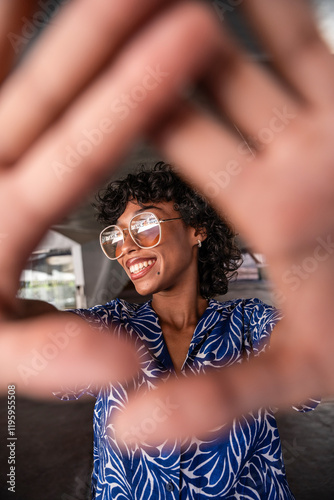 Smiling latin woman in patterned blouse framed by hands photo