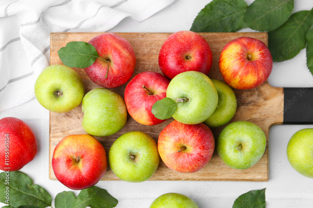 Fotografie Fresh ripe apples and green leaves on white table, top view