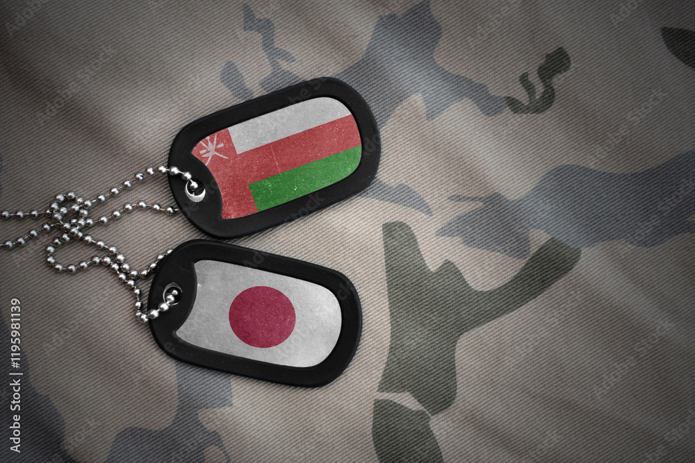 Φωτογραφία vintage army blank, dog tag with flag of oman and japan on the khaki texture background