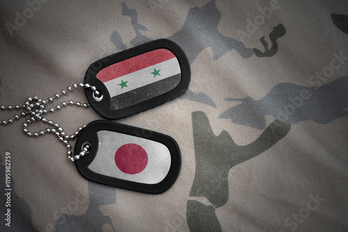 vintage army blank, dog tag with flag of syria and japan on the khaki texture background. military concept. photo