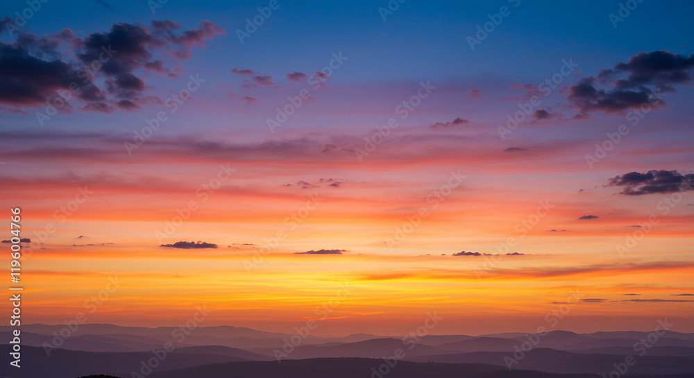 Fototapeta premium Breathtaking Sunset Over Rolling Hills and Mountains