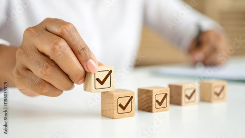hand placing wooden block with checkmark, symbolizing progress