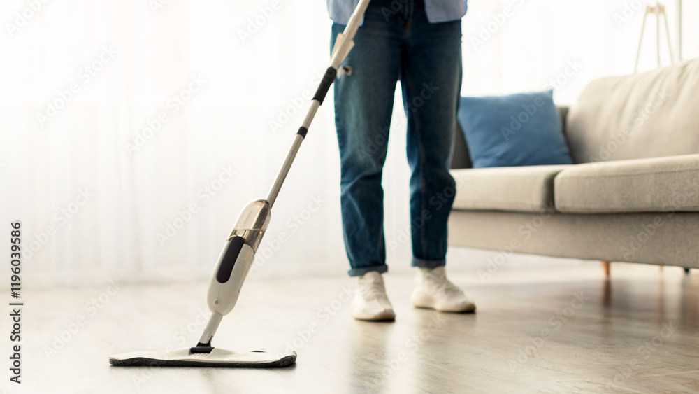 Fototapeta premium Closeup cropped low section of woman washing hardwood laminate flooring using water spray mop pad and refillable bottle with cleaning agent. Chores Concept. Blurred Background, Free Copy Space