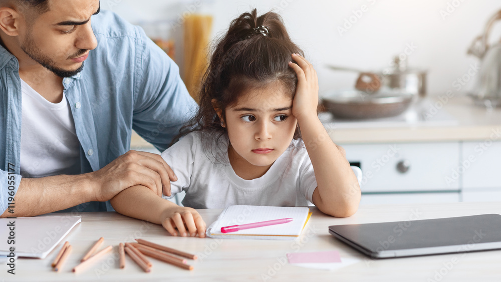 Young arab man single father comforting his upset little daughter, sitting at table with colorful pencils and notebook at kitchen, bored girl kid with unhappy face expression looking at copy space Young arab man single father comforting his upset little daughter, sitting at table with colorful pencils and notebook at kitchen, bored girl kid with unhappy face expression looking at copy space