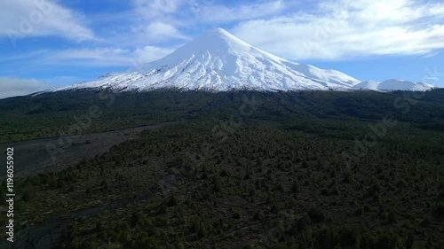 Aerial View of a Snow-Capped Volcano and Vast Forest Landscape