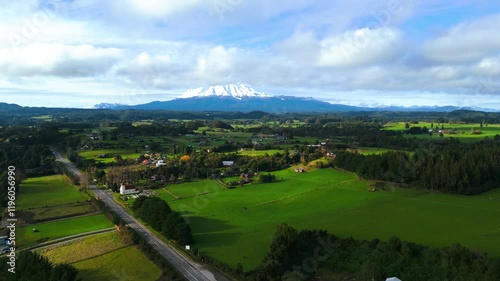 Aerial View of Picturesque Countryside with Green Fields and Snow-Capped Mountains