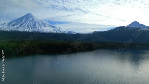 Aerial View of Snow-Capped Volcano and Lake Surrounded by Forest