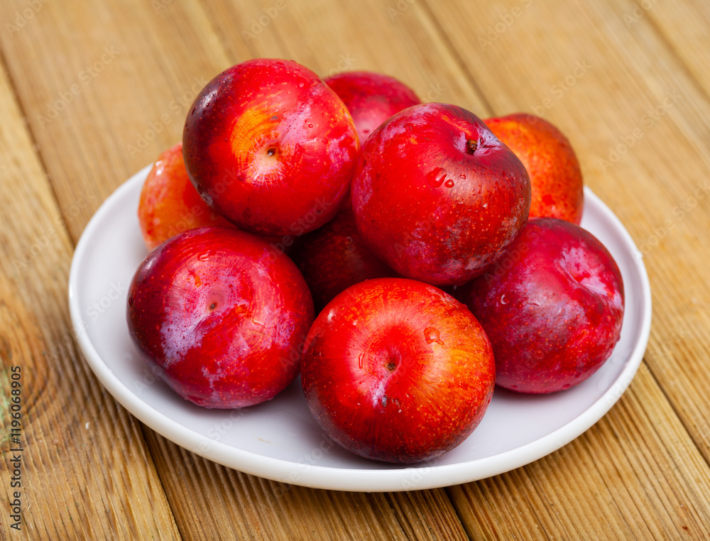 Tasty ripe red plum on a wooden surface. Healthy fruits Tasty ripe red plum on a wooden surface. Healthy fruits