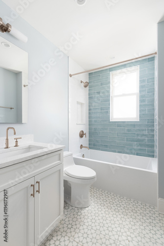 A bathroom with a white vanity cabinet, white marble countertop, and a shower with white and light blue subway tiles. No brands or labels.