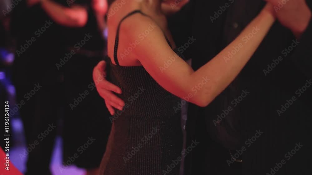 Couples dancing traditional latin argentinian dance milonga in the ballroom, tango salsa bachata kizomba lesson in red and purple lights, evening dance school class festival, performance rehearsal
