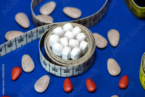 Tape measure with weight loss medications, dietary supplements and appetite suppressants, highlighting the risks of drug-based diets to combat obesity. Goals at the beginning of the year photo