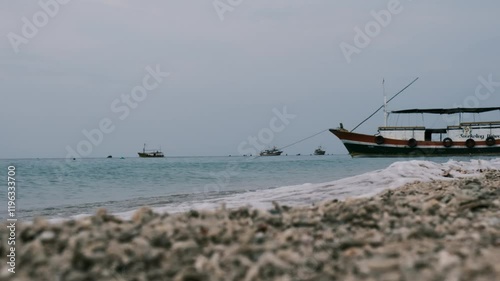 see several boats with waves crashing on shore