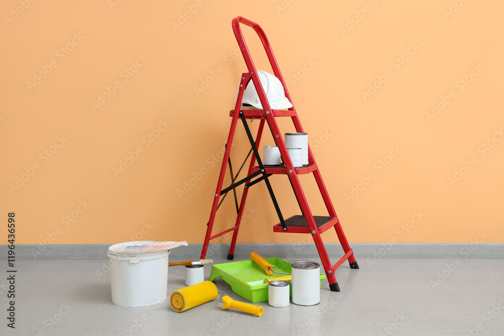 Stepladder with cans of paint and tools near orange wall Stepladder with cans of paint and tools near orange wall