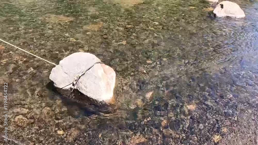 Slow motion of flowing river water and rocks