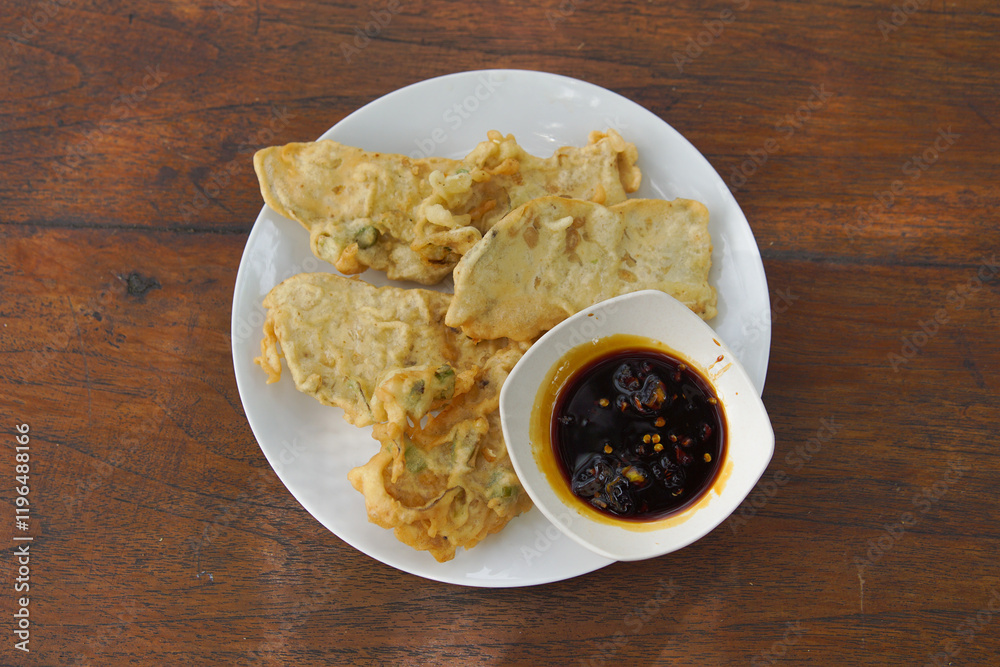 Mendoan Tempe with spicy sauce, Mendoan Tempe is a food made from Tempe fried with wheat flour Mendoan Tempe with spicy sauce, Mendoan Tempe is a food made from Tempe fried with wheat flour