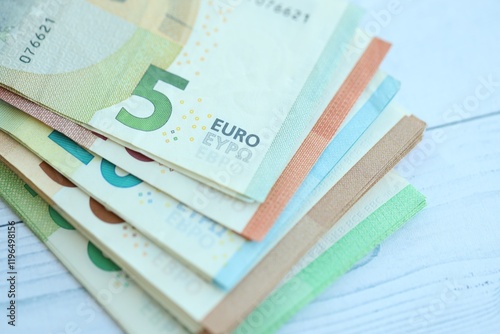 Big amount of different denominations of euro money bills on wooden background photo