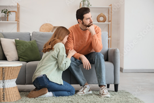 Young woman apologizing to her husband at home photo