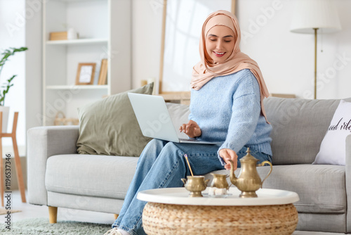 Young Muslim woman with lap...