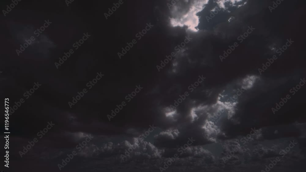Huge dark storm cloud moving, with internal flashes of light.