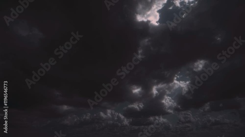 Huge dark storm cloud moving, with internal flashes of light.