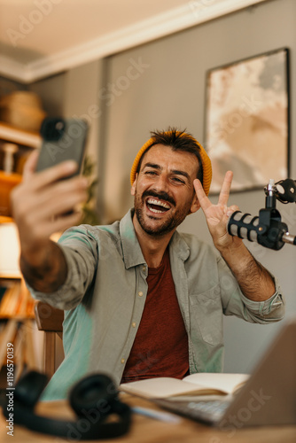 Smiling man hosting a podcast, speaking into a microphone in a bright space
