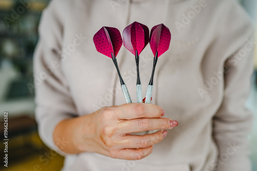 close up of woman handhold a pink dart ready for playing with them photo