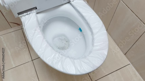 Modern toilet with automatic touch hygienic seat. Safety polyethylene replaceable lining from bacteria and germs, close-up