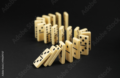 Domino effect. Tiles falling on black background